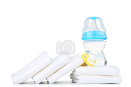 Foto de Pañales para bebés con chupete y botella de agua aislada sobre fondo blanco - Imagen libre de derechos