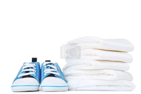 Photo for Baby diapers with pair of shoes isolated on white background - Royalty Free Image
