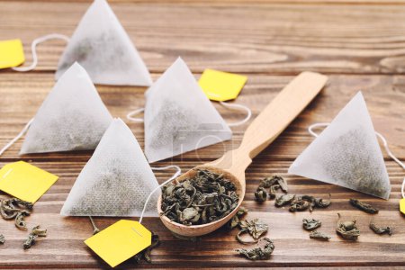 Téléchargez les photos : Sachets de thé avec thé sec dans une cuillère sur une table en bois - en image libre de droit