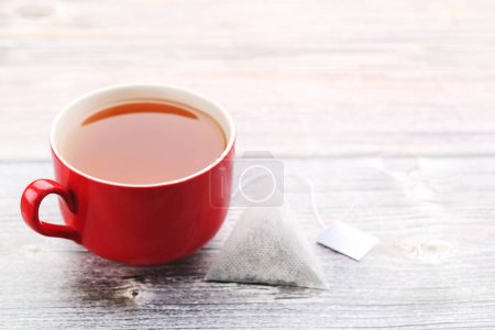Téléchargez les photos : Tasse de thé avec sachet de thé sur table en bois - en image libre de droit