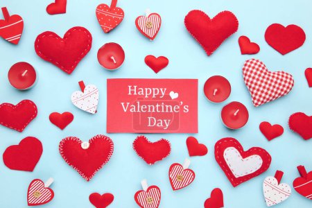 Téléchargez les photos : Coeurs avec bougies et texte Joyeuse Saint Valentin sur fond bleu - en image libre de droit
