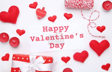 Foto de Inscripción Feliz día de San Valentín con caja de regalo y corazones sobre fondo blanco - Imagen libre de derechos