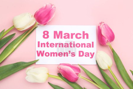 Foto de Flores de tulipanes y tarjeta con texto 8 de marzo Día Internacional de la Mujer sobre fondo rosa - Imagen libre de derechos
