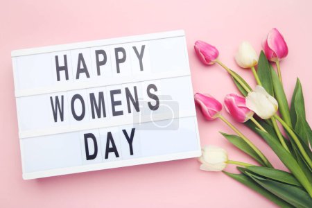 Téléchargez les photos : Bouquet flowers of tulips and lightbox with text Happy Women's Day on pink background - en image libre de droit