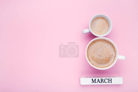 Téléchargez les photos : Deux tasses de café en forme 8 Mars sur fond rose - en image libre de droit