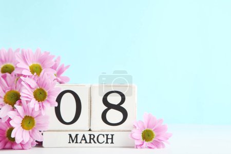 Foto de Flores de crisantemos y calendario de cubos de madera sobre fondo azul - Imagen libre de derechos
