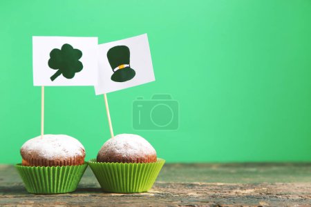 Foto de Cupcakes and flags with picture of hat and clover leaf on green background - Imagen libre de derechos