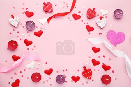 Foto de Valentine hearts with ribbons and candles on pink background - Imagen libre de derechos