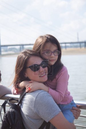 Mutter und Tochter auf der Brücke. Das Konzept des Familienglücks.