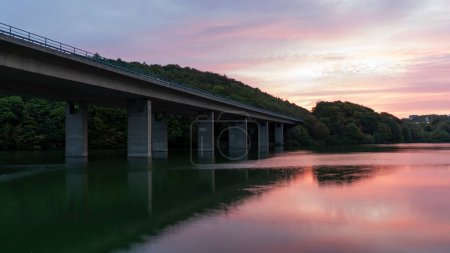 Brücke über den Fluss am Abend. Schöner Sonnenuntergang über dem Fluss.