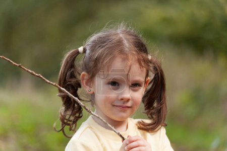 Portrait d'une petite fille aux cheveux longs dans la nature.