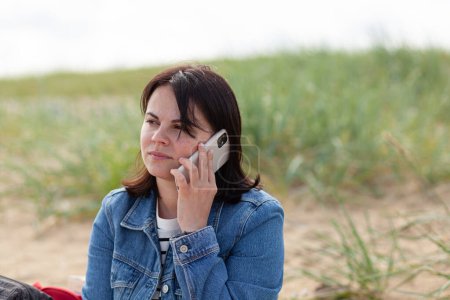 Junge Frau telefoniert am Ostseestrand