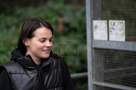 Junge Frau in einem Park an einem kalten Wintertag mit einem Lächeln