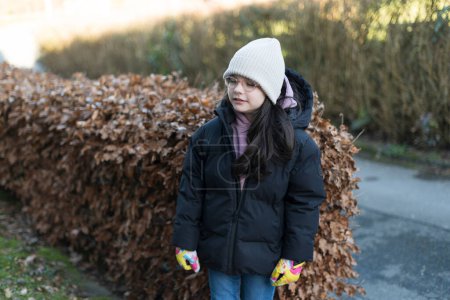 Outdoor-Lifestyle-Porträt einer jungen schönen, glücklichen und hübschen asiatischen Chinesin in Wintermantel und Hut, die auf der Straße spaziert