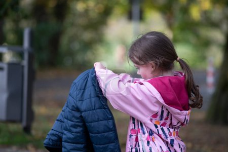 Little girl in autumn park, back view, shallow depth of field