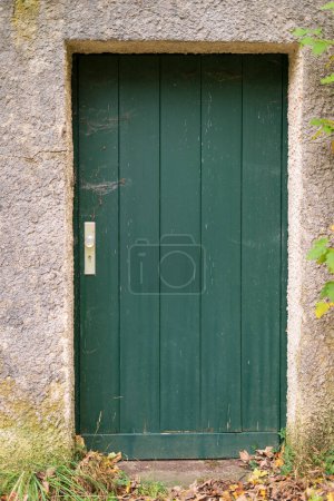 Téléchargez les photos : Porte verte en bois dans un mur de pierre d'une ancienne ferme. - en image libre de droit