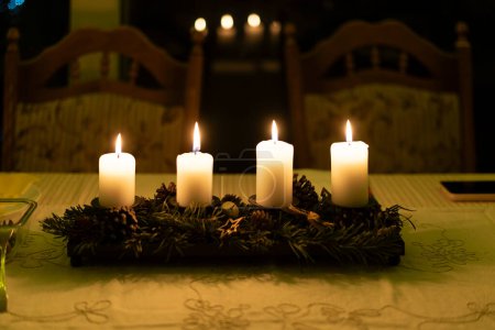 Weihnachtsgedecke mit Kerzen und Kranz in der Nacht. Selektiver Fokus.