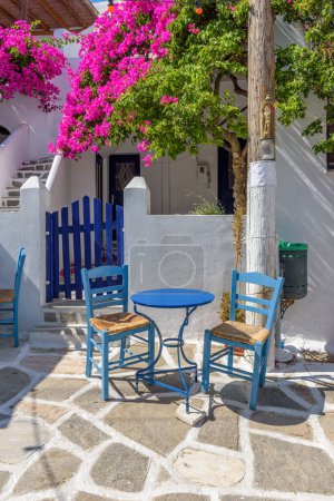 Traditionelle Gasse mit weiß getünchten Häusern, einer griechischen Taverne und einer Bougainvillea auf der Insel Prodromos Paros