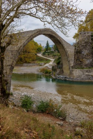 Photo for View of the stone bridge of Konitsa over Aoos river with automn colors , in Zagori, Epirus, Greece. - Royalty Free Image