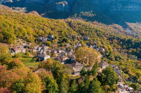 Téléchargez les photos : Vue aérienne du village traditionnel Mikro Papigo avec des bâtiments en pierre et la montagne astraka comme arrière-plan pendant la saison d'automne en zagori Grèce - en image libre de droit