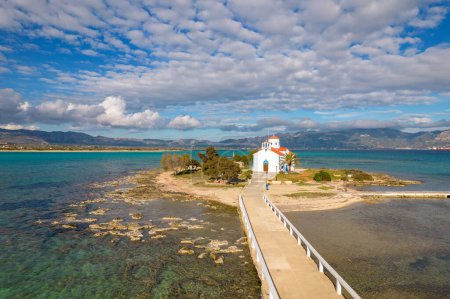Téléchargez les photos : Vue aérienne de l'église Saint Spyridon sur l'île d'Elafonisos. Situé dans le sud du Péloponnèse Elafonisos est une petite île très célèbre pour les plages de sable fin paradisiaque et les eaux turquoise. - en image libre de droit