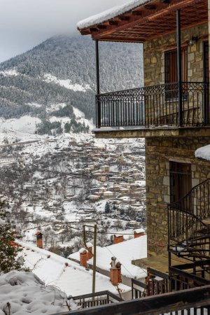 Foto de El pintoresco pueblo de Metsovo durante la temporada de invierno cubierto de nieve con sus edificios de piedra antiguos arquitectónicos situados al este de Zagori, Epiro, Grecia, Europa - Imagen libre de derechos