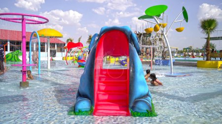 Photo for Water park, bright multi-colored slides with a pool. A water park without people on a summer day. Aquapark sliders with pool. Sikar, Rajasthan, India - Royalty Free Image