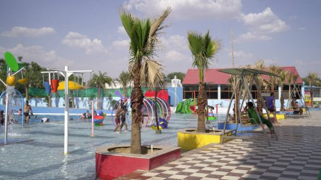 Téléchargez les photos : Parc aquatique, toboggans multicolores lumineux avec une piscine. Un parc aquatique sans personne un jour d'été. Curseurs Aquapark avec piscine. Sikar, Rajasthan, Inde - en image libre de droit