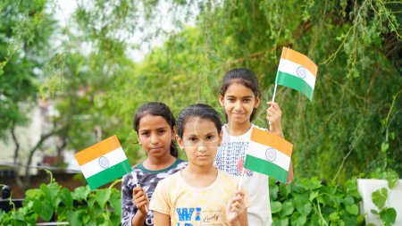 Photo for Three Indian child celebrating Independence or Republic day, Cute little Indian child holding, waving or running with Tricolour flag with white background - Royalty Free Image