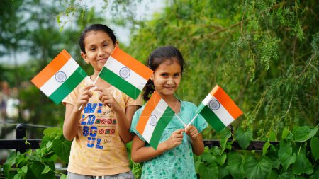 Photo for Two Indian child celebrating Independence or Republic day, Cute little Indian child holding, waving or running with Tricolour flag with white background - Royalty Free Image