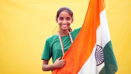 Photo for Indian girl celebrating indian independence day or Republic Day concept. Girl with Indian National Tricolour Flag, Isolated over yellow background. - Royalty Free Image