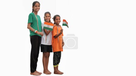 Photo for Cheerful indian little girls kids wearing tricolour t-shirt holding indian national flag isolated on white background, happy independence day, 15th of august, republic day, Protestantism concept. - Royalty Free Image