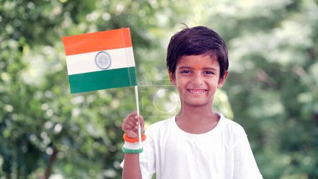 Photo for Cute little boy with Indian National Tricolour Flag, Isolated over nature background. Suitable for Independence Day or Republic Day concept - Royalty Free Image
