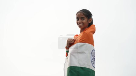 Photo for Young girl covering in Indian flag. Celebrating Independence day or Republic day in India. Kid showing pride of Tiranga - Royalty Free Image