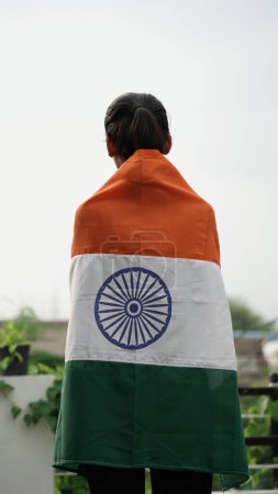 Photo for Young girl covering in Indian flag. Celebrating Independence day or Republic day in India. Kid showing pride of Tiranga - Royalty Free Image