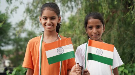 Photo for Two Indian students or children holding or waving Tricolour. celebrating Independence or Republic day - Royalty Free Image