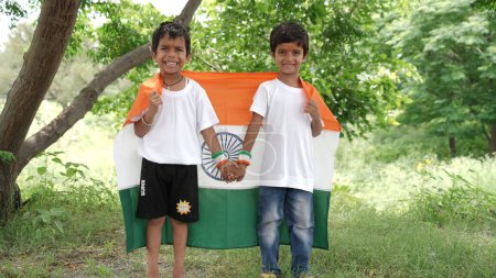 Photo for Cute little boys holding Indian flag in their hands and smiling. Celebrating Independence day or Republic day in India. Kid showing pride of Tiranga - Royalty Free Image