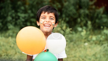 Photo for Cute little boy with Indian Flags painted on cheeks  holding balloons - Royalty Free Image