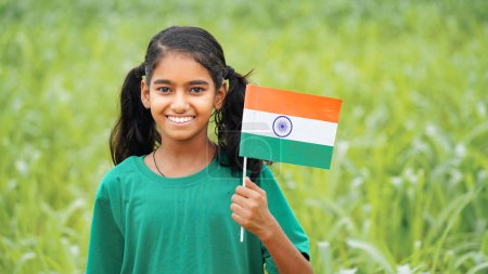 Foto de Niño indio feliz sosteniendo bandera nacional india. Niños indios celebrando el Día de la Independencia o el Día de la República de India. - Imagen libre de derechos