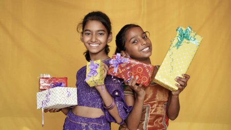 Téléchargez les photos : Deux sœurs indiennes heureuses debout avec des boîtes-cadeaux - en image libre de droit