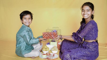 Foto de Felices hermanos indios sentados juntos con cajas de regalo - Imagen libre de derechos