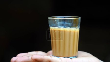 Photo for Indian masala tea or chai in traditional glass, wooden background. cafe, retro, restaurant, hotel concepts. The early morning cutting chai - Royalty Free Image