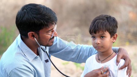 Photo for Indian young doctor of pediatrician holding stethoscope checking heartbeat of sick boy kid. health checkup, children medical insurance care. healthcare Concept - Royalty Free Image