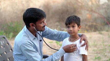 Foto de Joven médico indio de pediatra con estetoscopio comprobando el latido del niño enfermo. chequeo de salud, seguro médico para niños. Concepto sanitario - Imagen libre de derechos