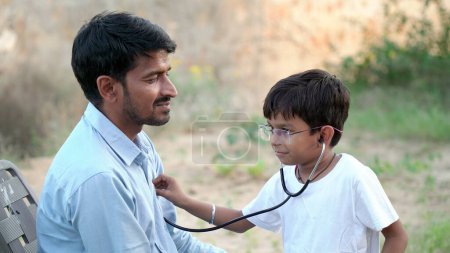 Foto de Médico indio de pediatría con estetoscopio comprobando el latido del niño enfermo. chequeo de salud, seguro médico para niños. Concepto sanitario - Imagen libre de derechos