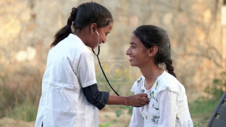 Téléchargez les photos : Enfant indien médecin d'un pédiatre tenant un stéthoscope vérifiant les battements de coeur d'un enfant malade. bilan de santé, soins médicaux pour enfants. concept de santé - en image libre de droit