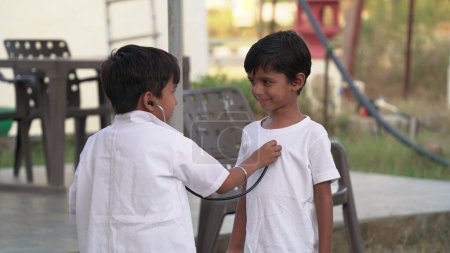 Photo for Indian kid doctor of pediatrician holding stethoscope checking heartbeat of sick boy kid. health checkup, children medical insurance care. healthcare Concept - Royalty Free Image