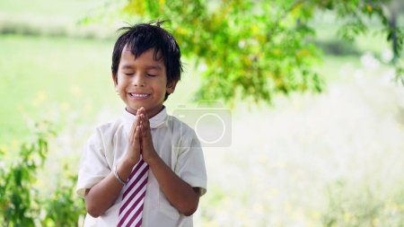Foto de Un niño rezando por la mañana. Pequeño niño asiático orando, Las manos dobladas en concepto de oración por la fe, la espiritualidad y la religión. niño niño niño con fe y confianza - Imagen libre de derechos