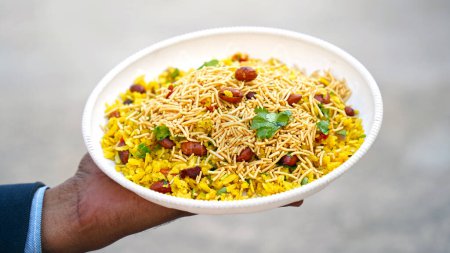 Téléchargez les photos : Indian Breakfast Dish Poha Aussi connu sous le nom de Pohe ou Aalu poha composé de riz battu ou de riz aplati. Les flocons de riz sont légèrement frits à l'huile avec moutarde, curcuma, oignon, feuilles de curry - en image libre de droit