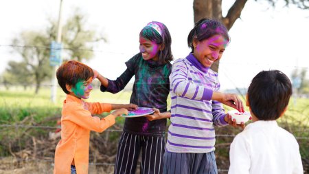 Photo for Happy Cute Smiling looking kids playing with paints in their fingers. Holi Festival of colors. India Festival of colours. - Royalty Free Image